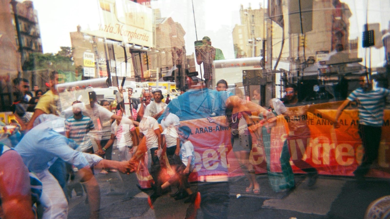 Double-exposure Holga photo of a New York City street procession, layered with signs, dancers, and movement—evoking the fractured path of modern discovery.